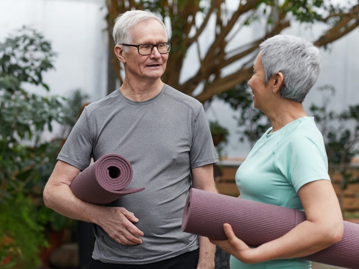 Couple Holding Yoga Mats While Looking at Each Other