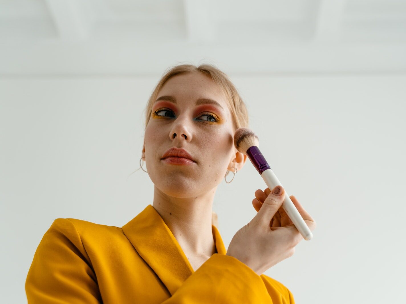 Woman in Yellow Blazer Putting Blusher on Her Face