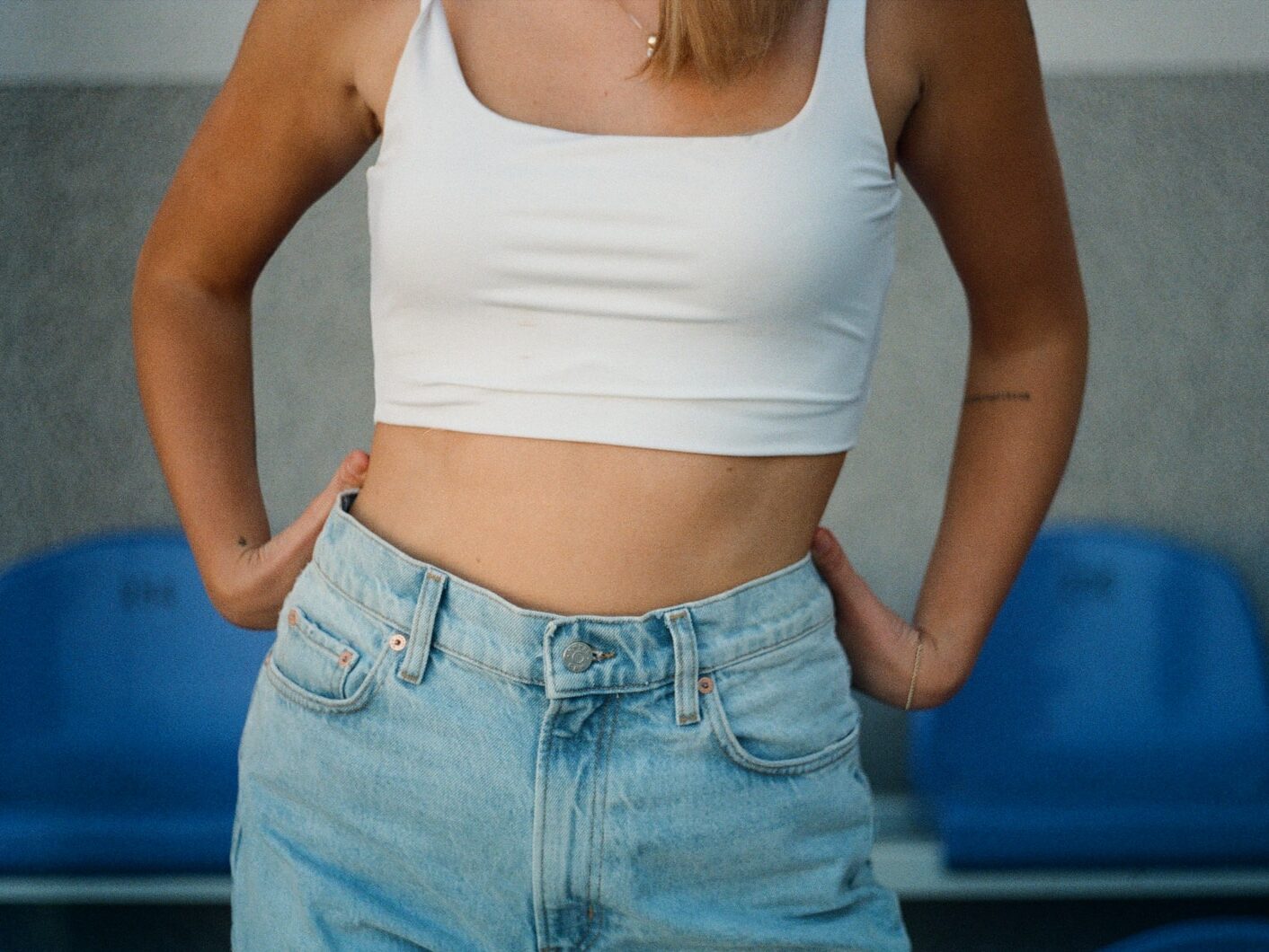 woman in white tank top and blue denim jeans