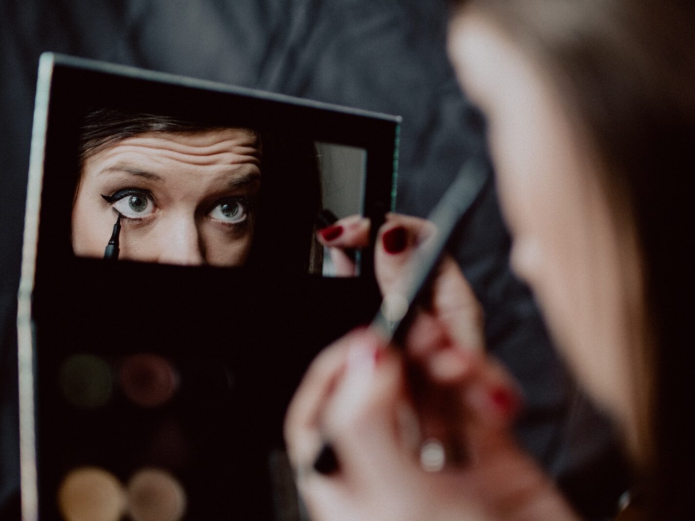 woman holding black framed mirror