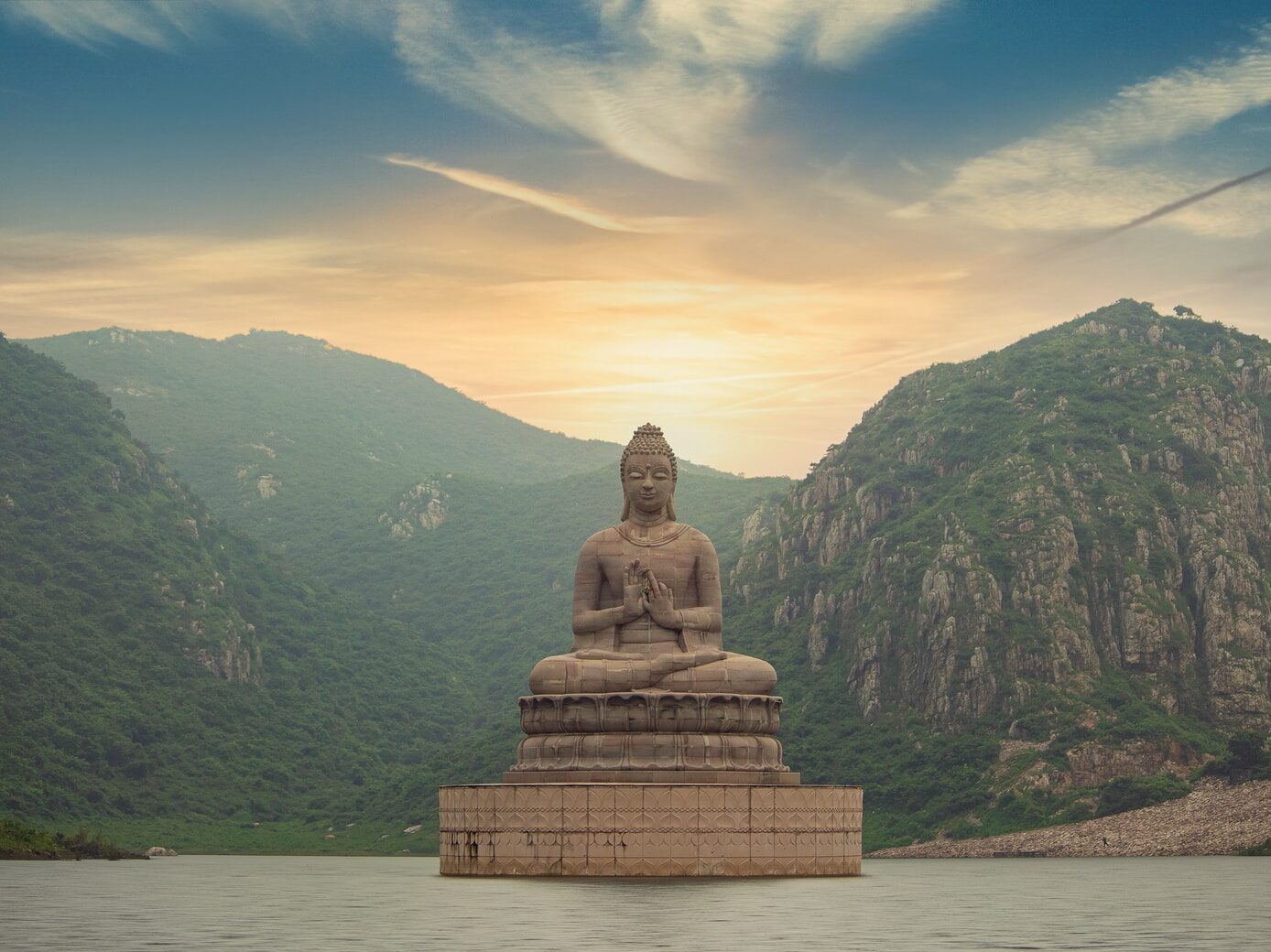 brown buddha statue near green mountain under blue sky during daytime