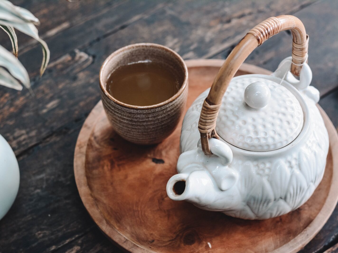 white and brown ceramic teapot on wooden tray