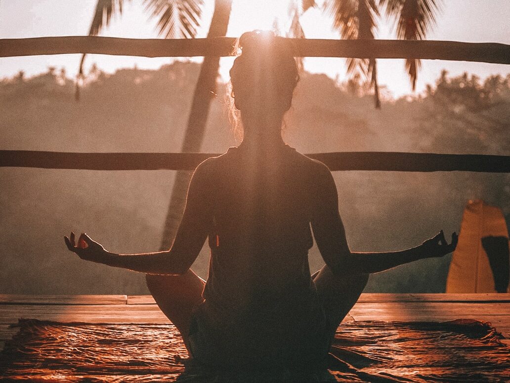 woman doing yoga meditation on brown parquet flooring