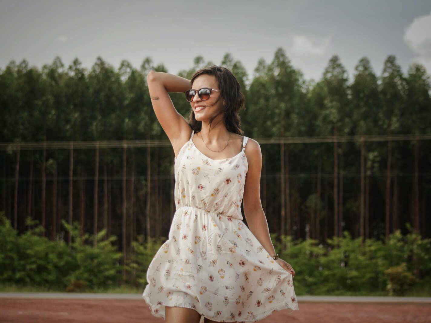 woman in white dress holder her hair