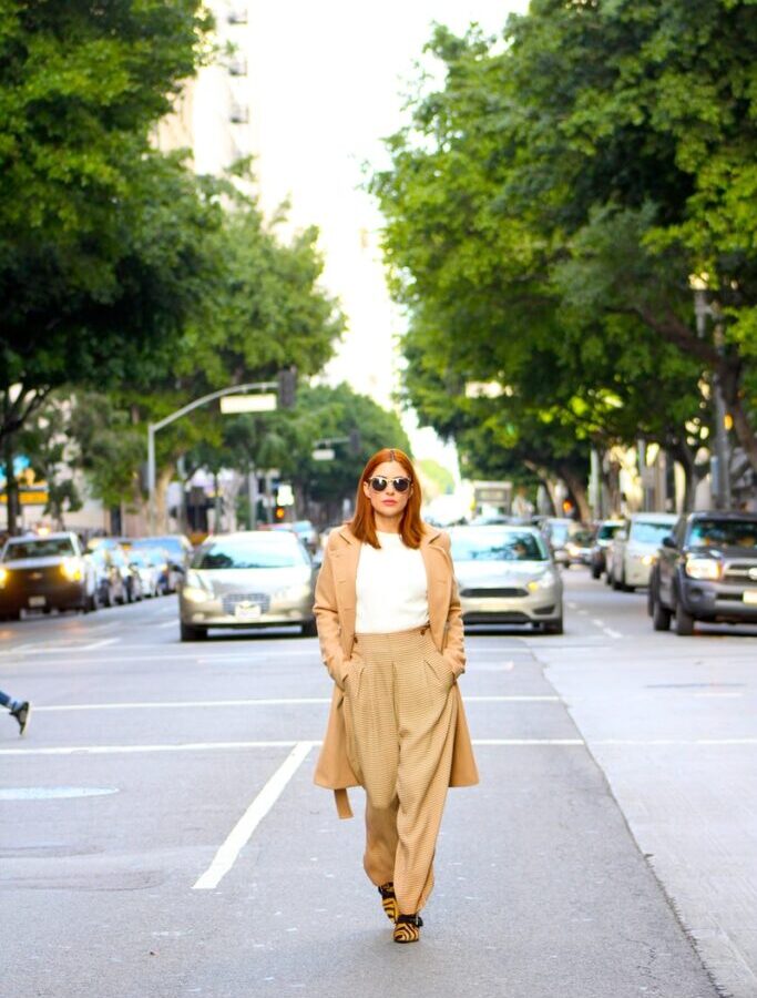 woman in brown dress standing on sidewalk during daytime