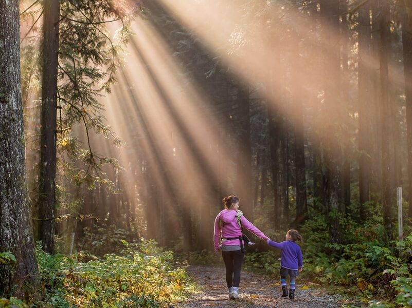 woman walking in forest with child
