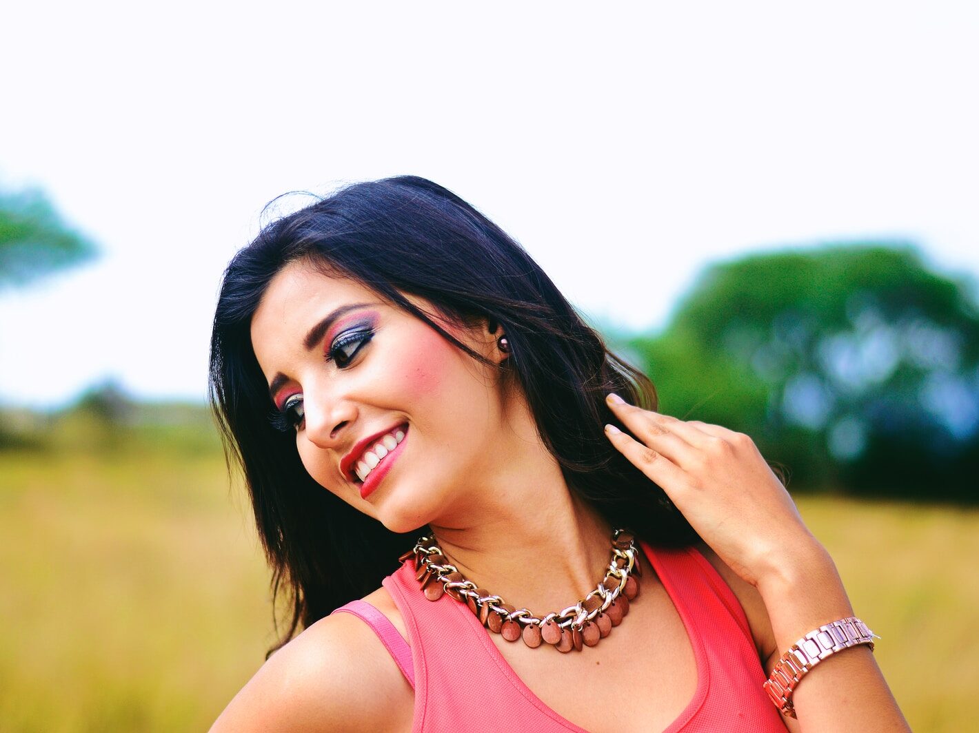 woman wearing pink sleeveless tops projecting while smiling selective photography