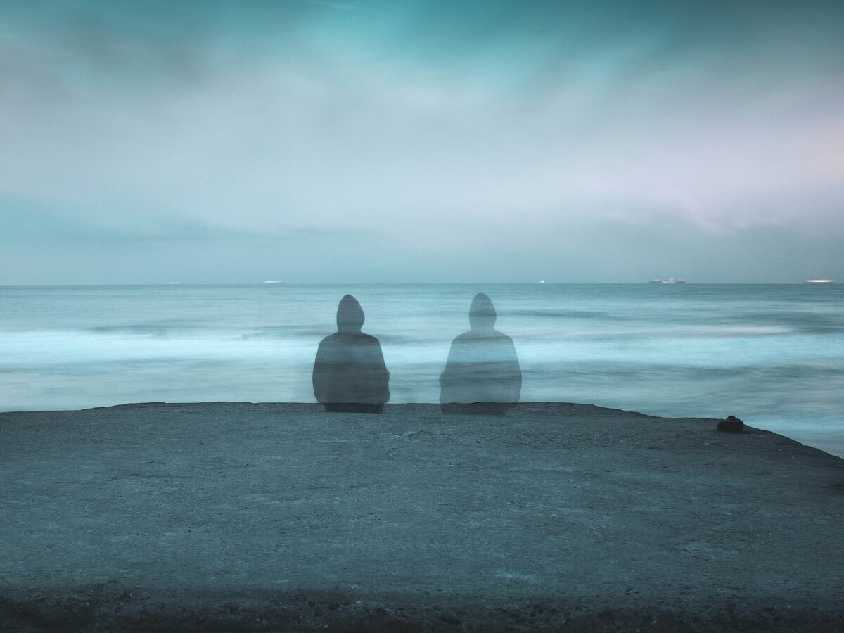 3 white and gray stone on black sand near body of water during daytime