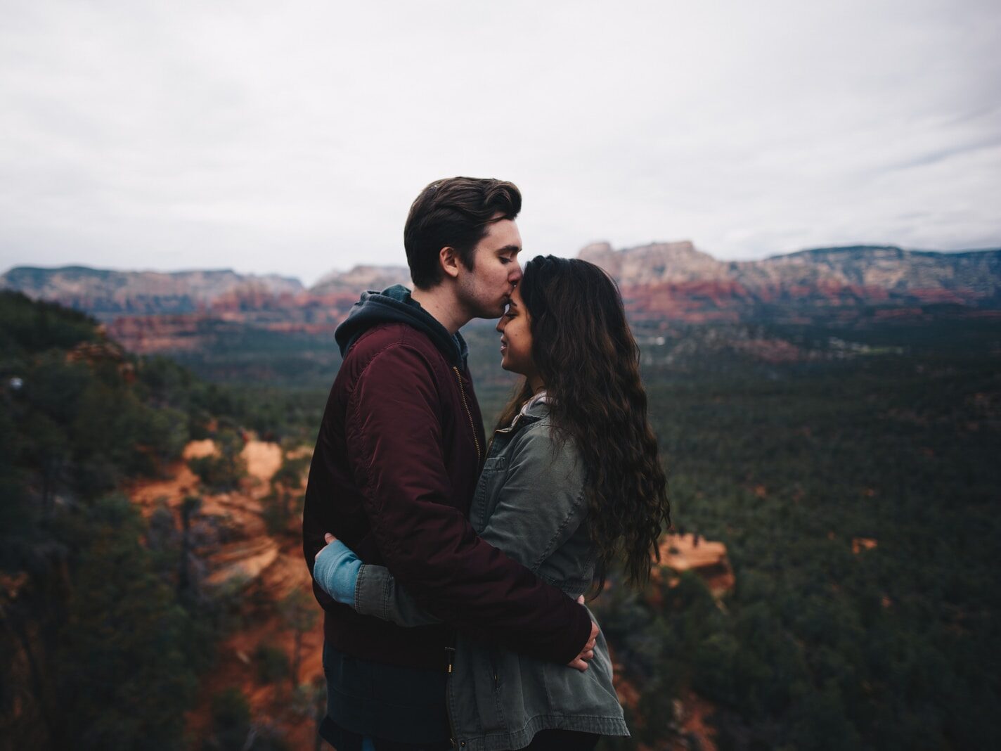 man kissing woman's forehead