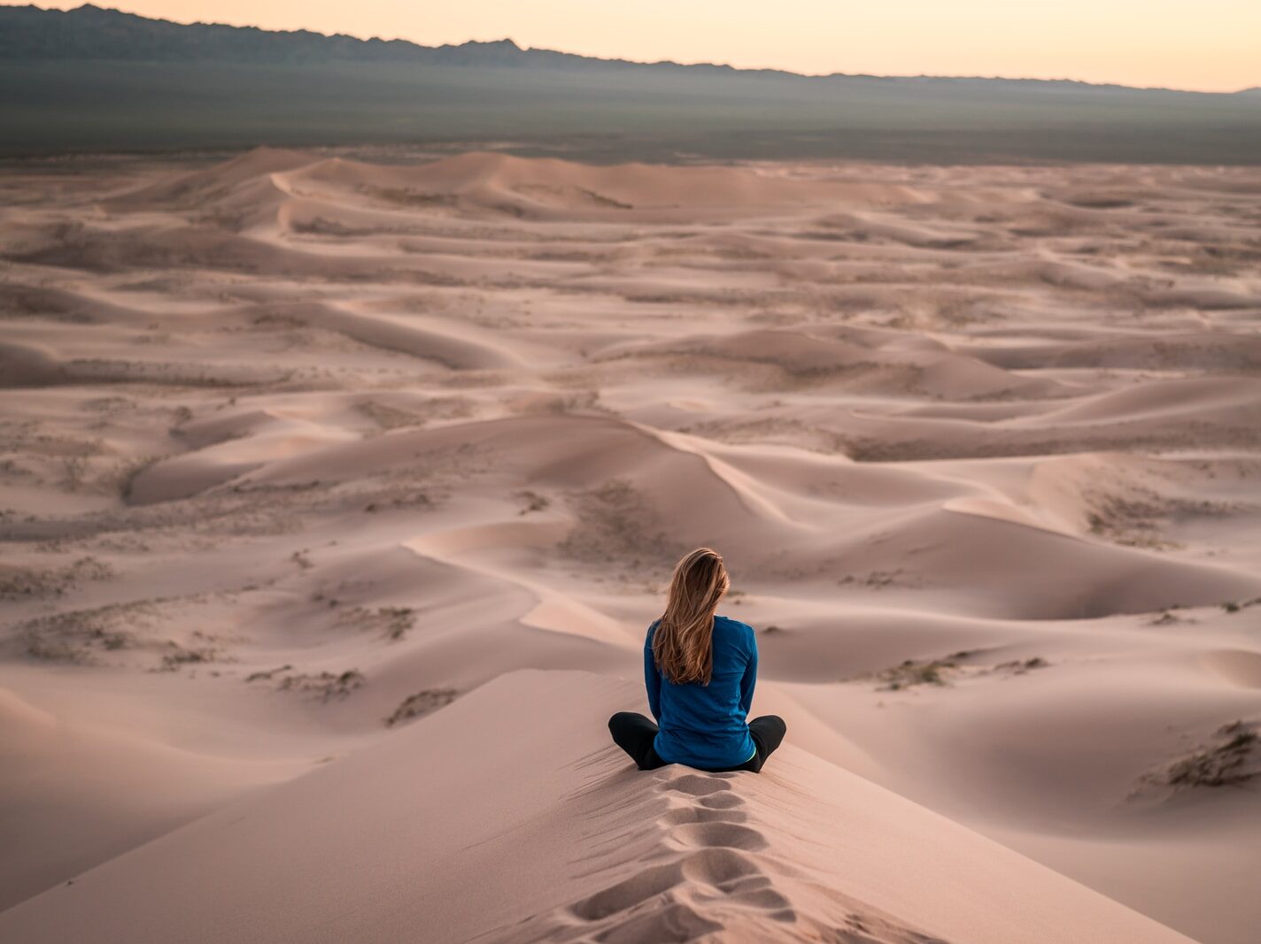 woman sitting on sand field
