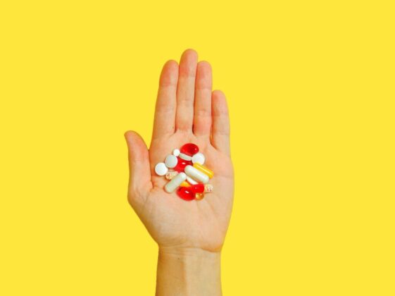 Person With Bunch Medication Pills on Hand