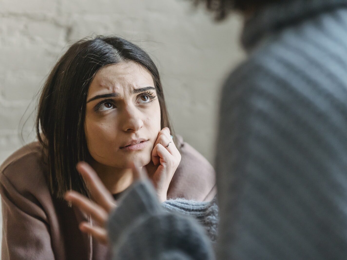 Sad woman looking at anonymous woman during conflict