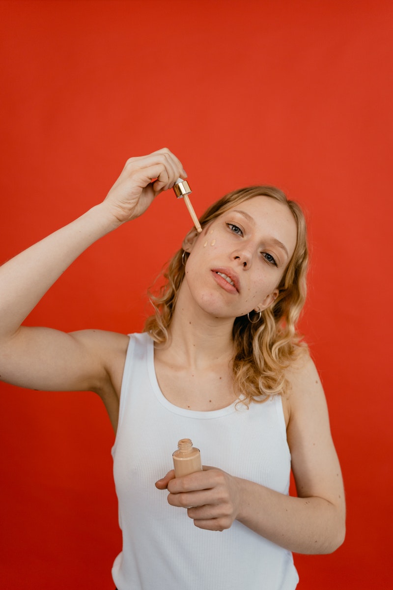 MART PRODUCTION - ČasProŽeny.cz A Woman in White Tank Top Applying a Concealer on Her Face