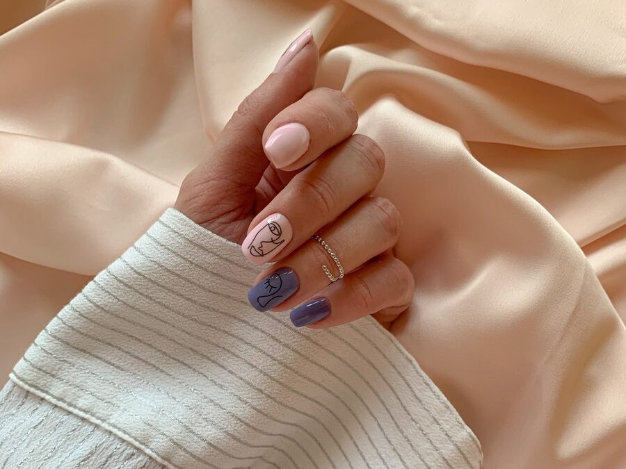 A Hand With Manicured Nails on White Textile