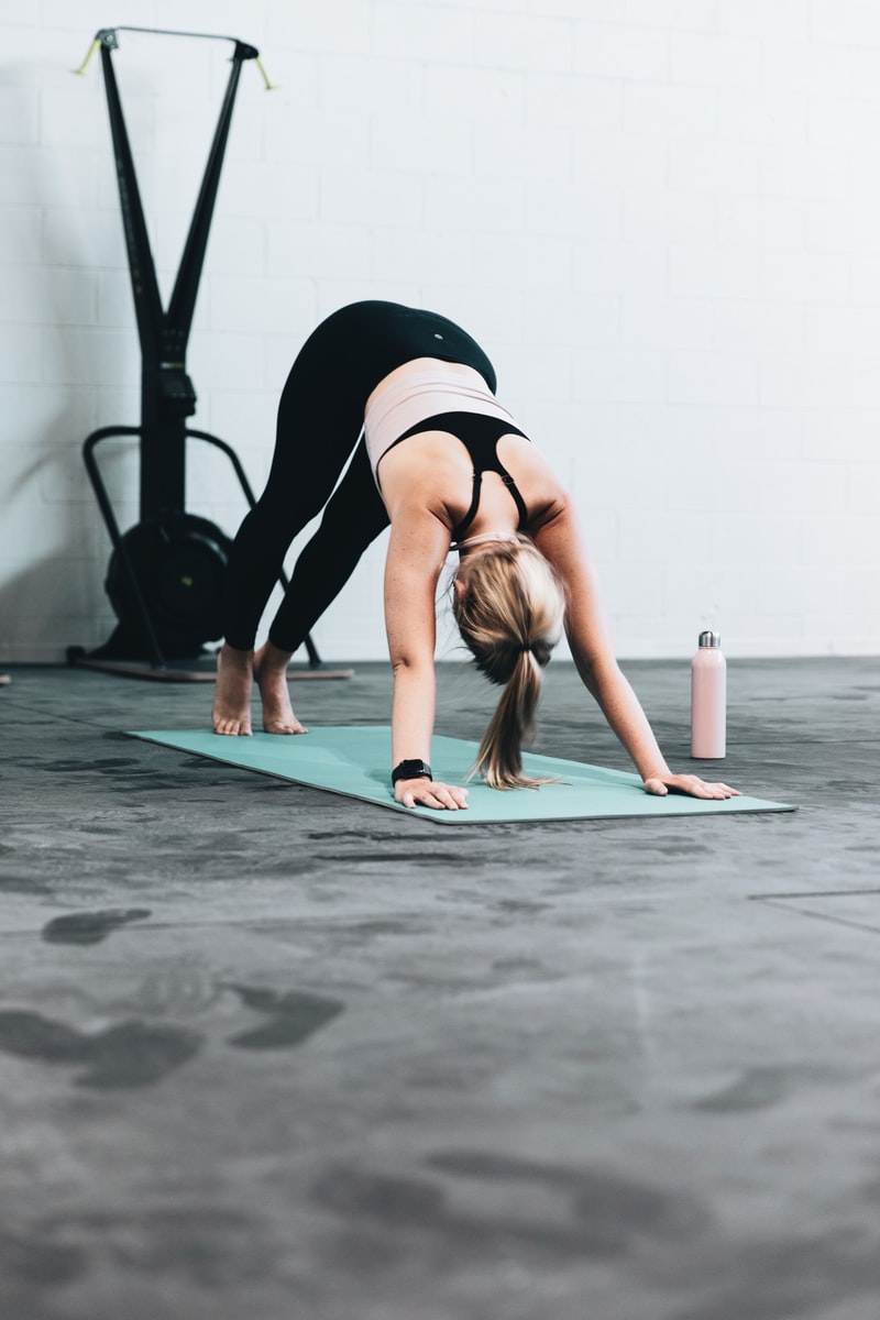 LOGAN WEAVER | @LGNWVR - ČasProŽeny.cz woman in black sports bra and blue denim jeans doing yoga