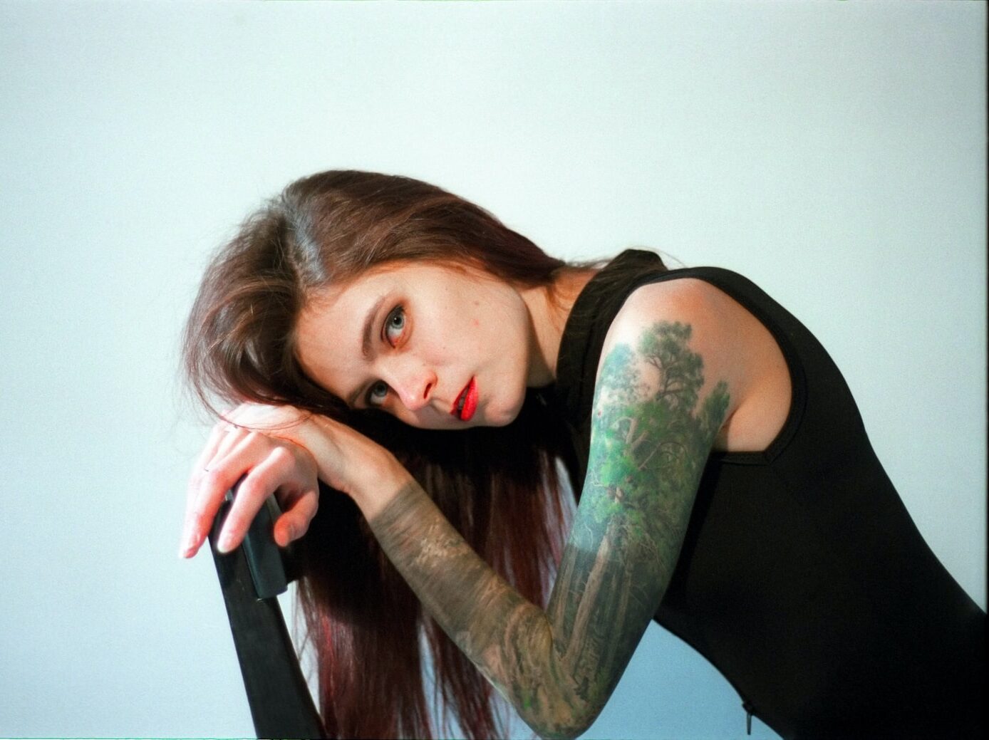 woman in black tank top sitting on black chair