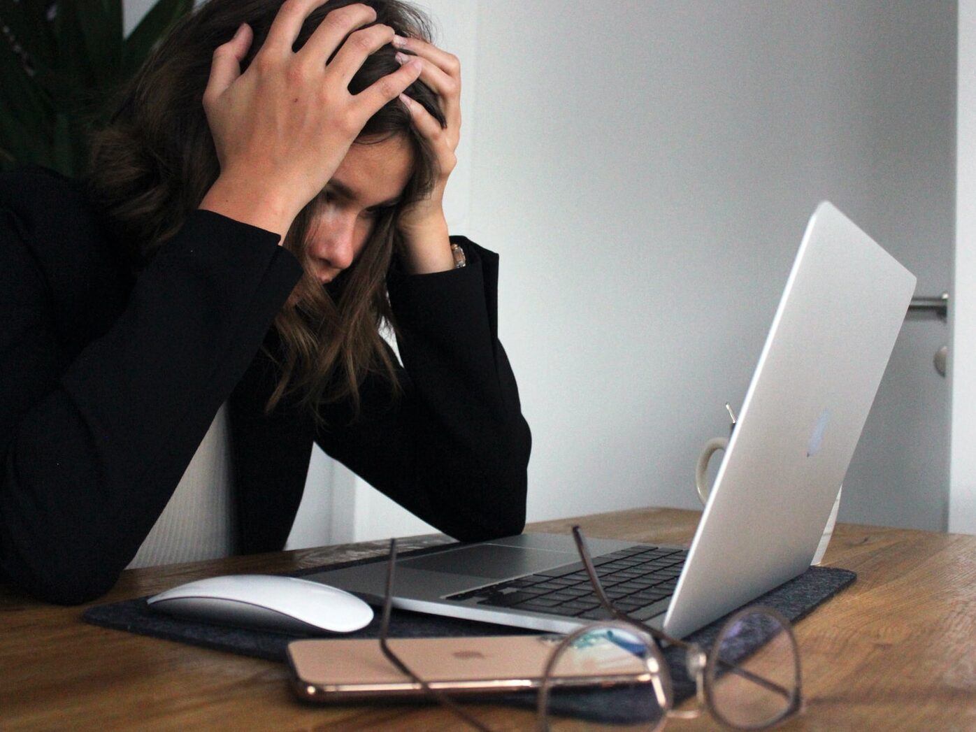 woman in black long sleeve shirt covering her face with her hands