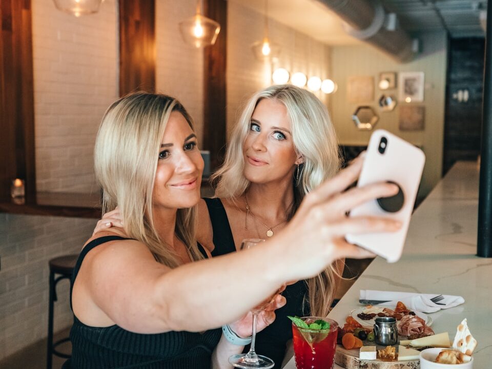 woman in black tank top holding white ceramic mug