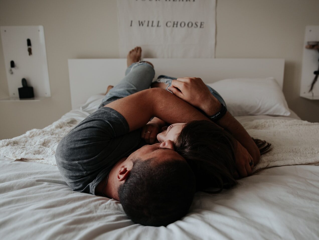 A man and woman cuddling together in bed.