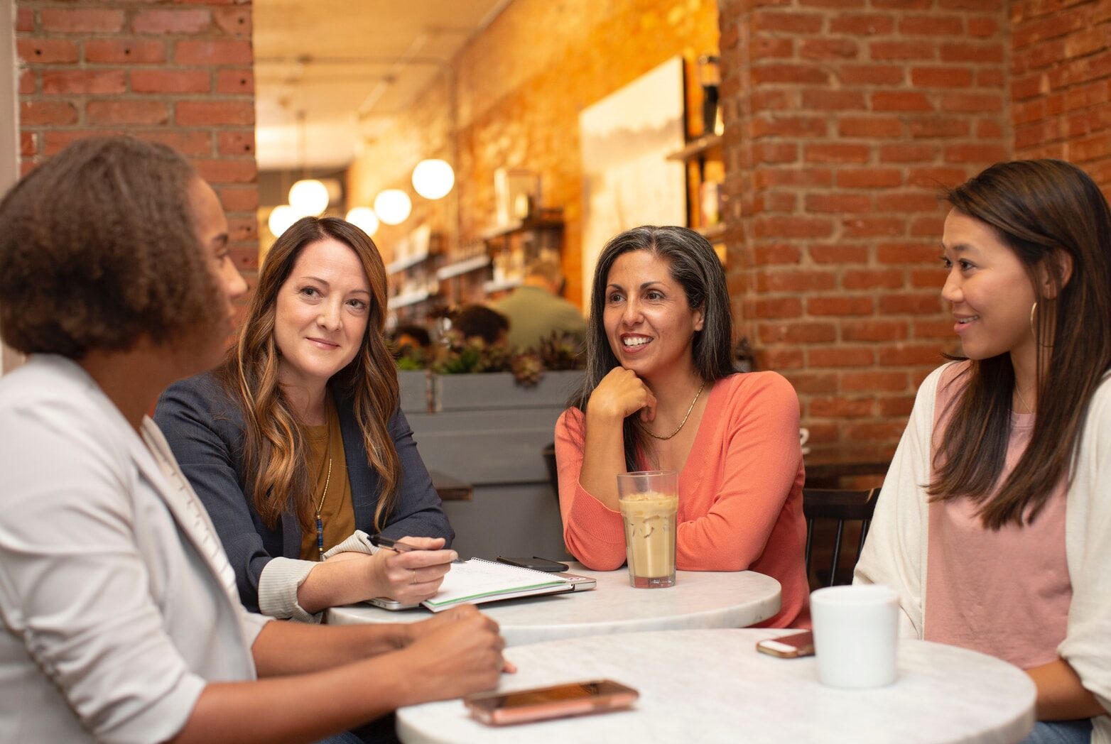 woman in black jacket sitting beside woman in white blazer