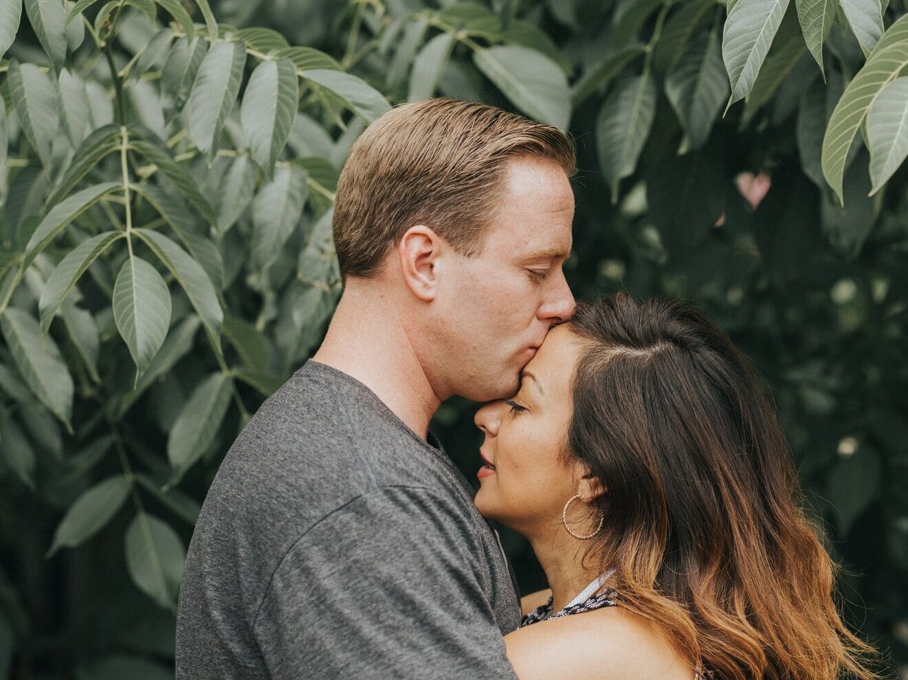 couple hugging near tree leafs
