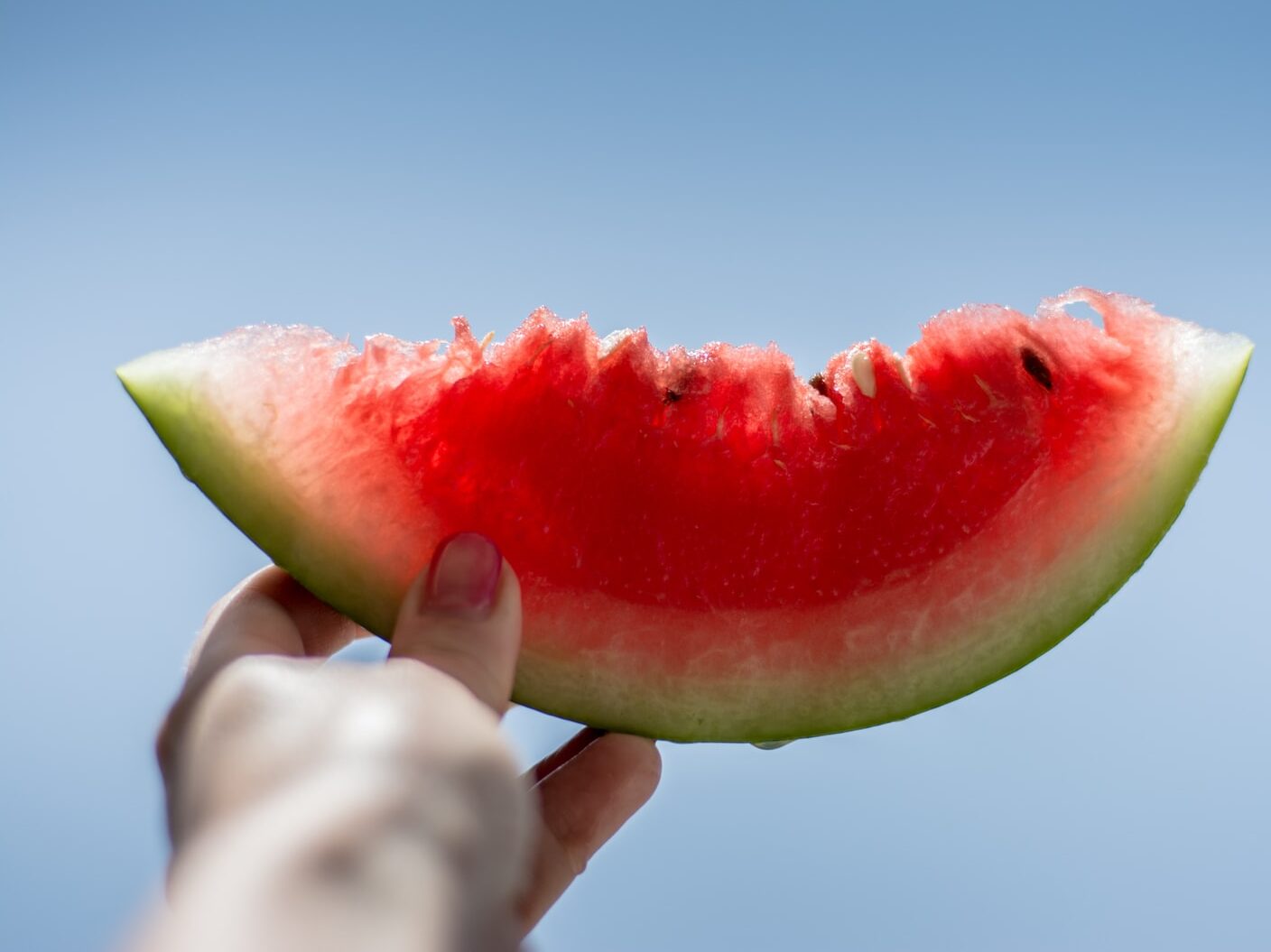 person holding sliced watermelon