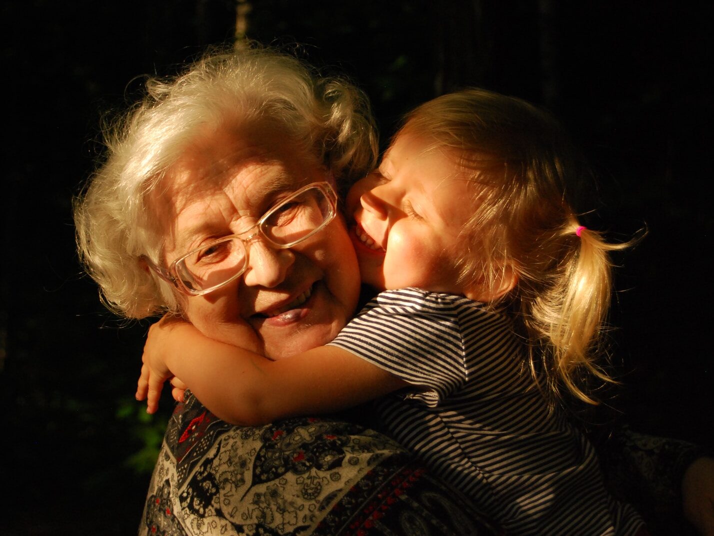 woman in black and white striped shirt hugging girl in black and white striped shirt