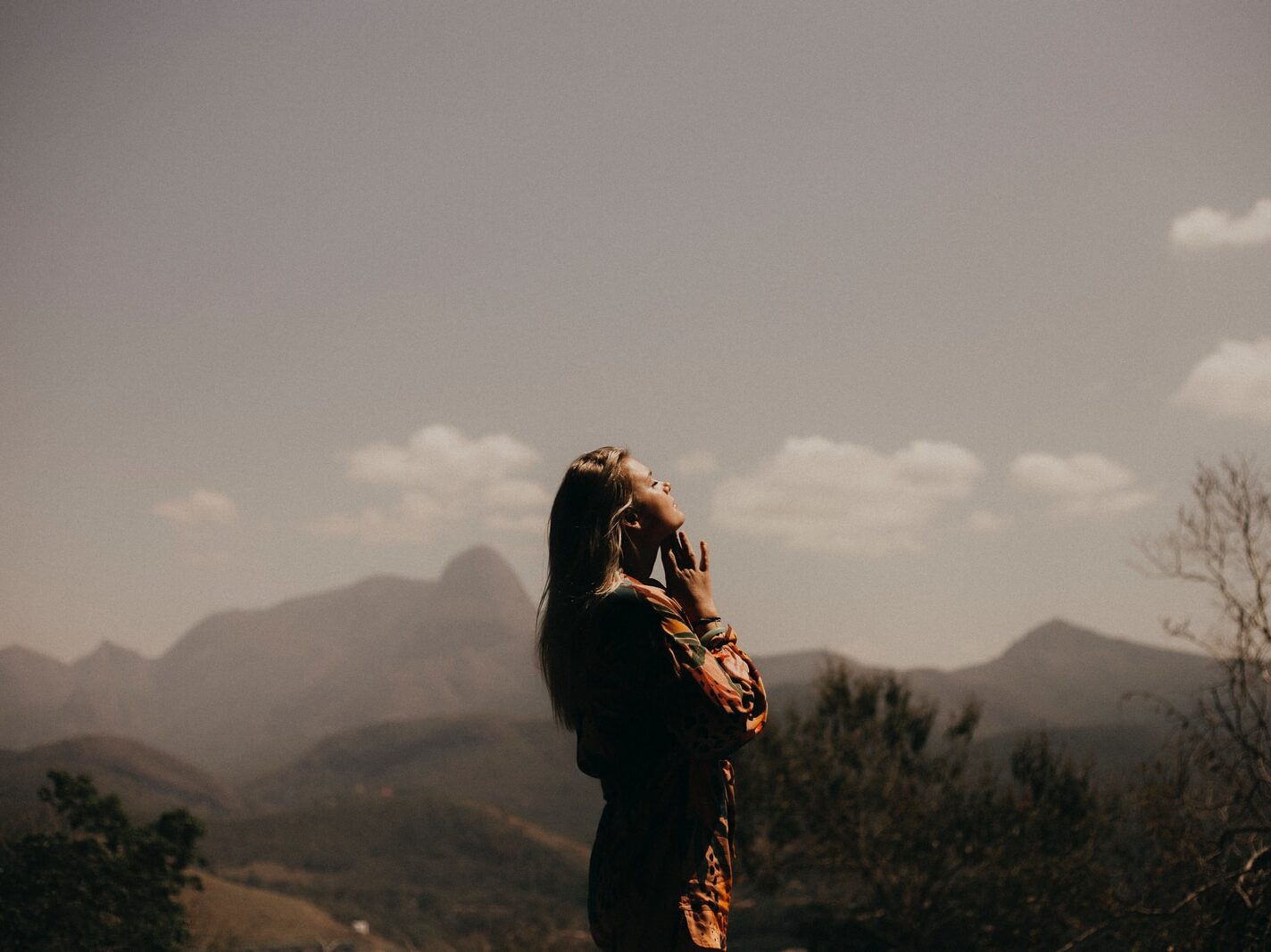 woman in black jacket standing on green grass field during daytime