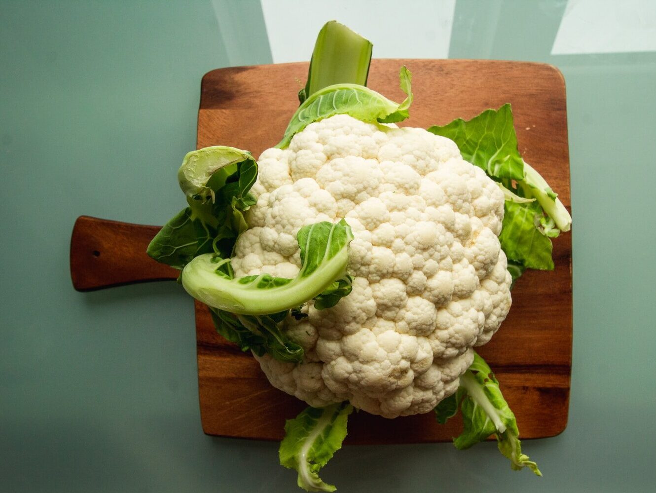 white cauliflower on brown wooden chopping board