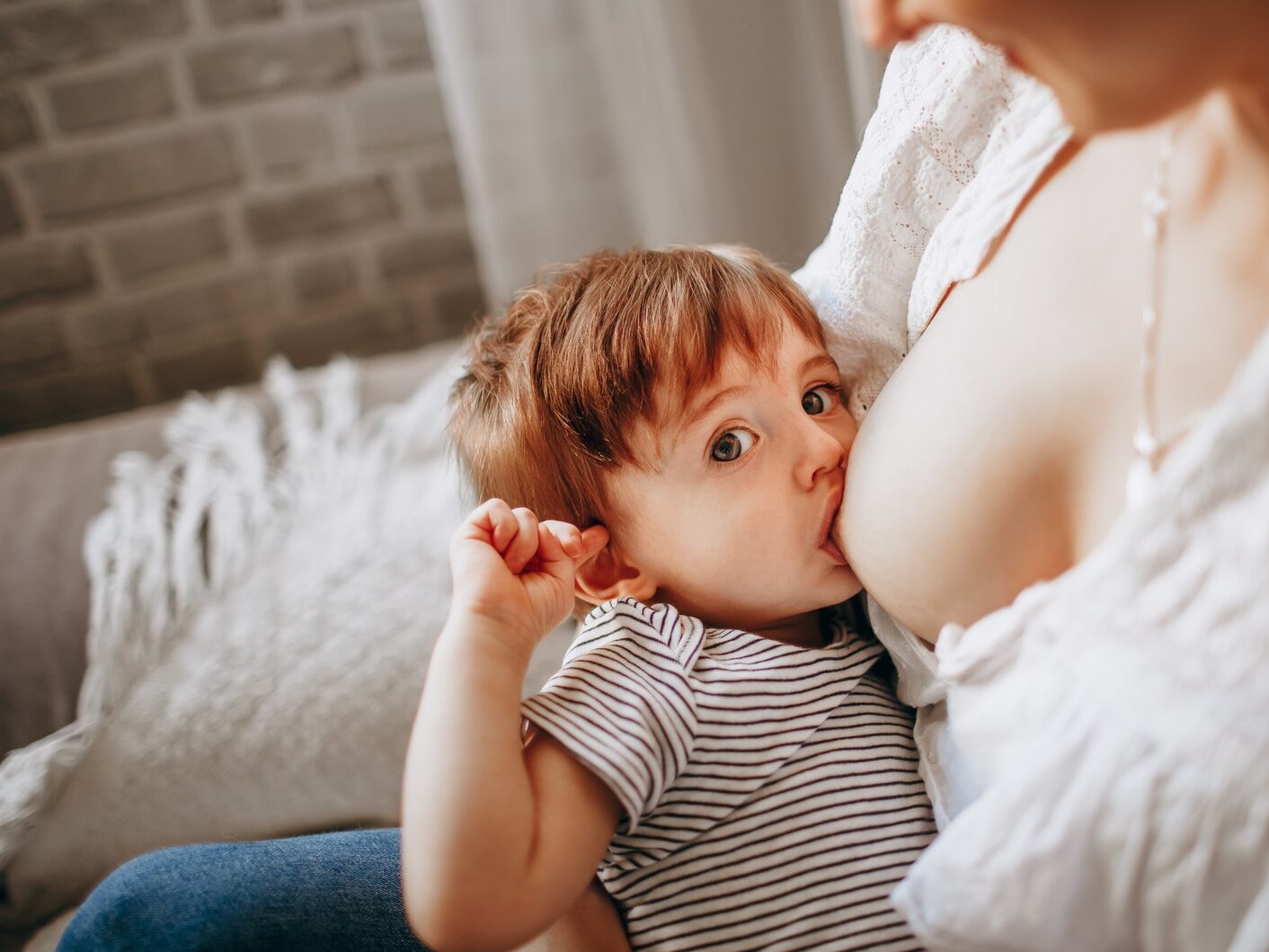 girl in white and black striped tank top lying on bed