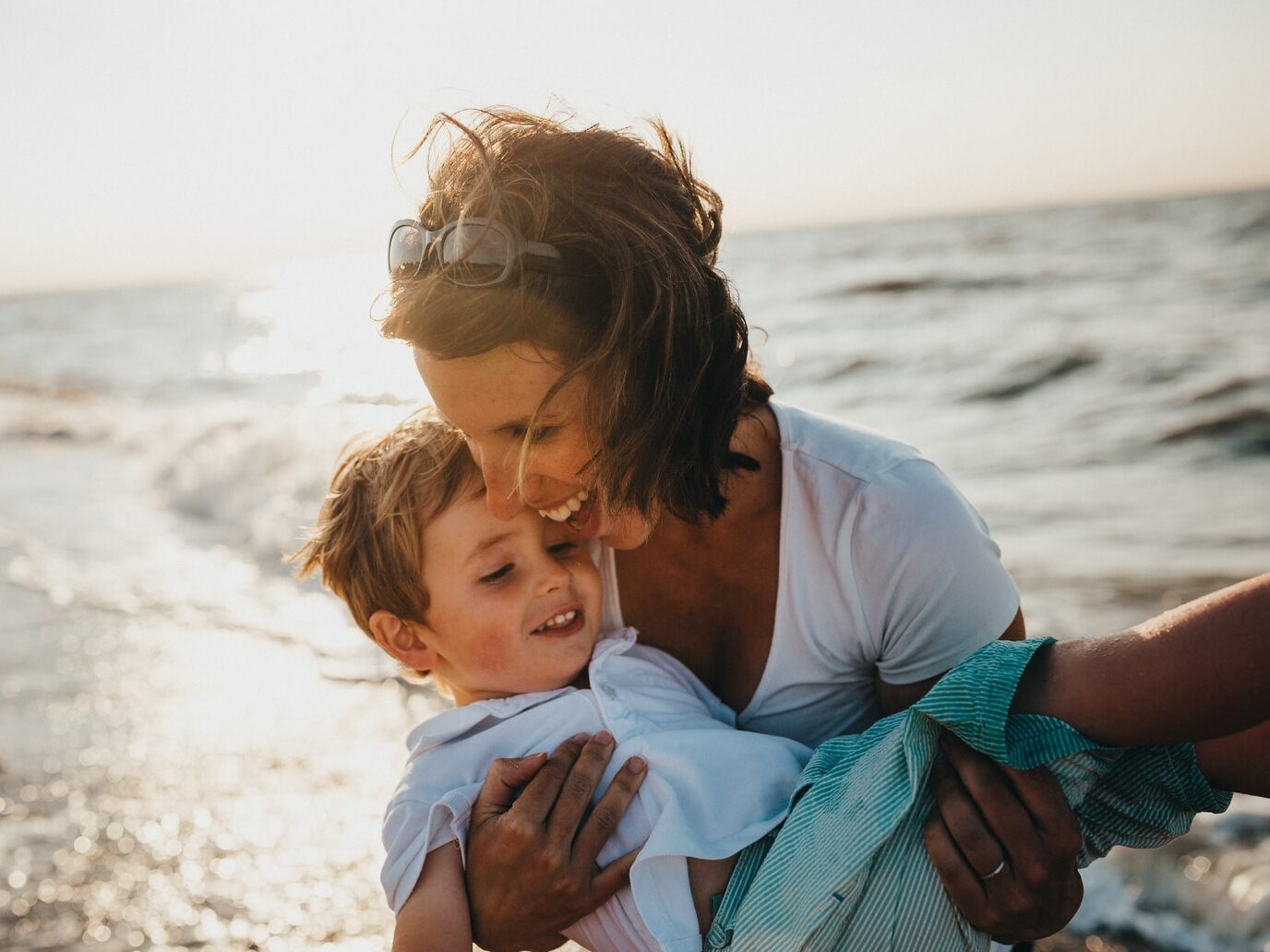 photo of mother and child beside body of water