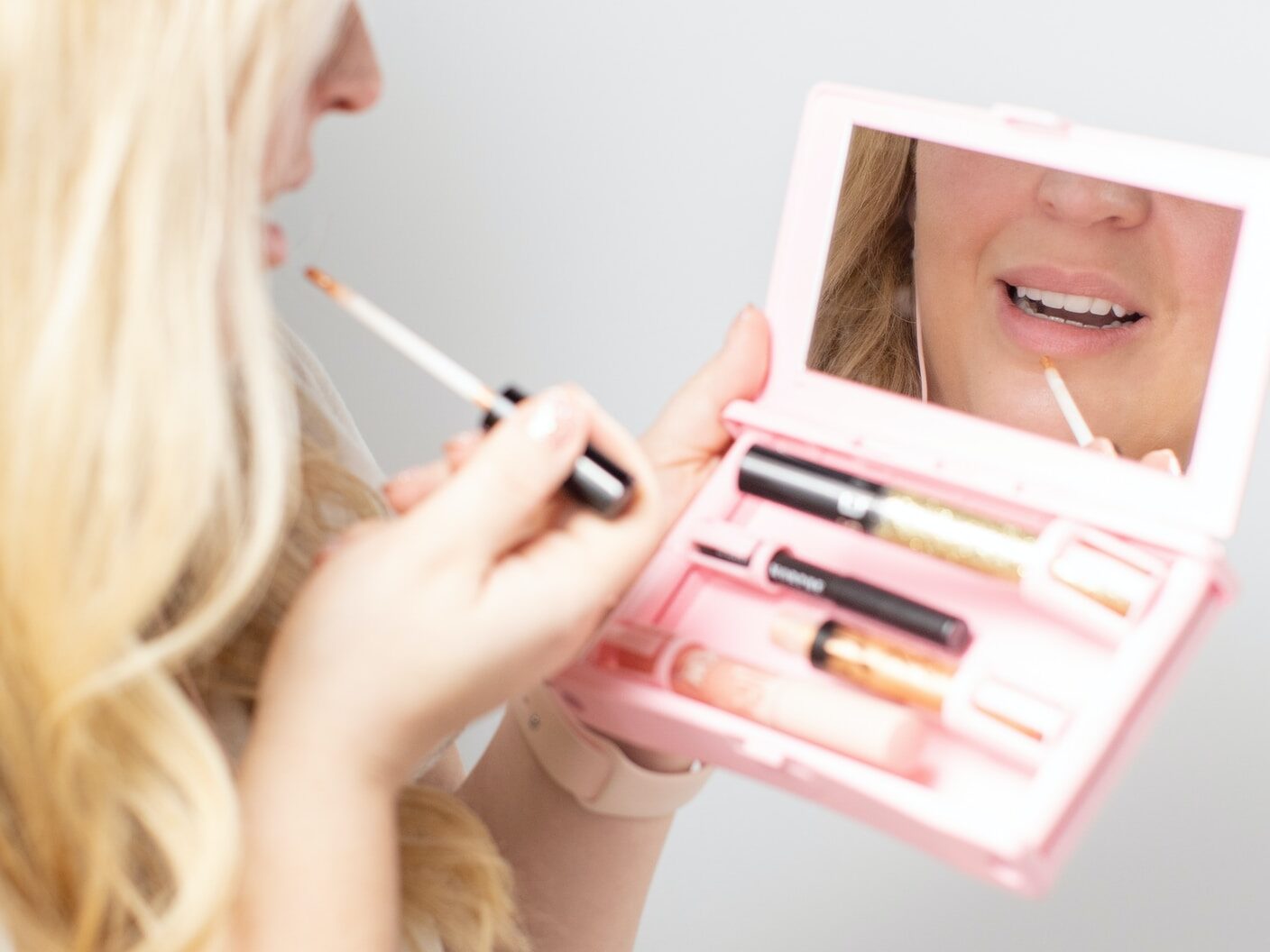 woman holding pink and white box with pen