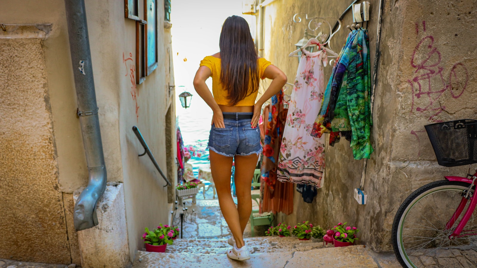dole777 - ČasProŽeny.cz woman in yellow tank top and blue denim shorts standing on concrete floor during daytime