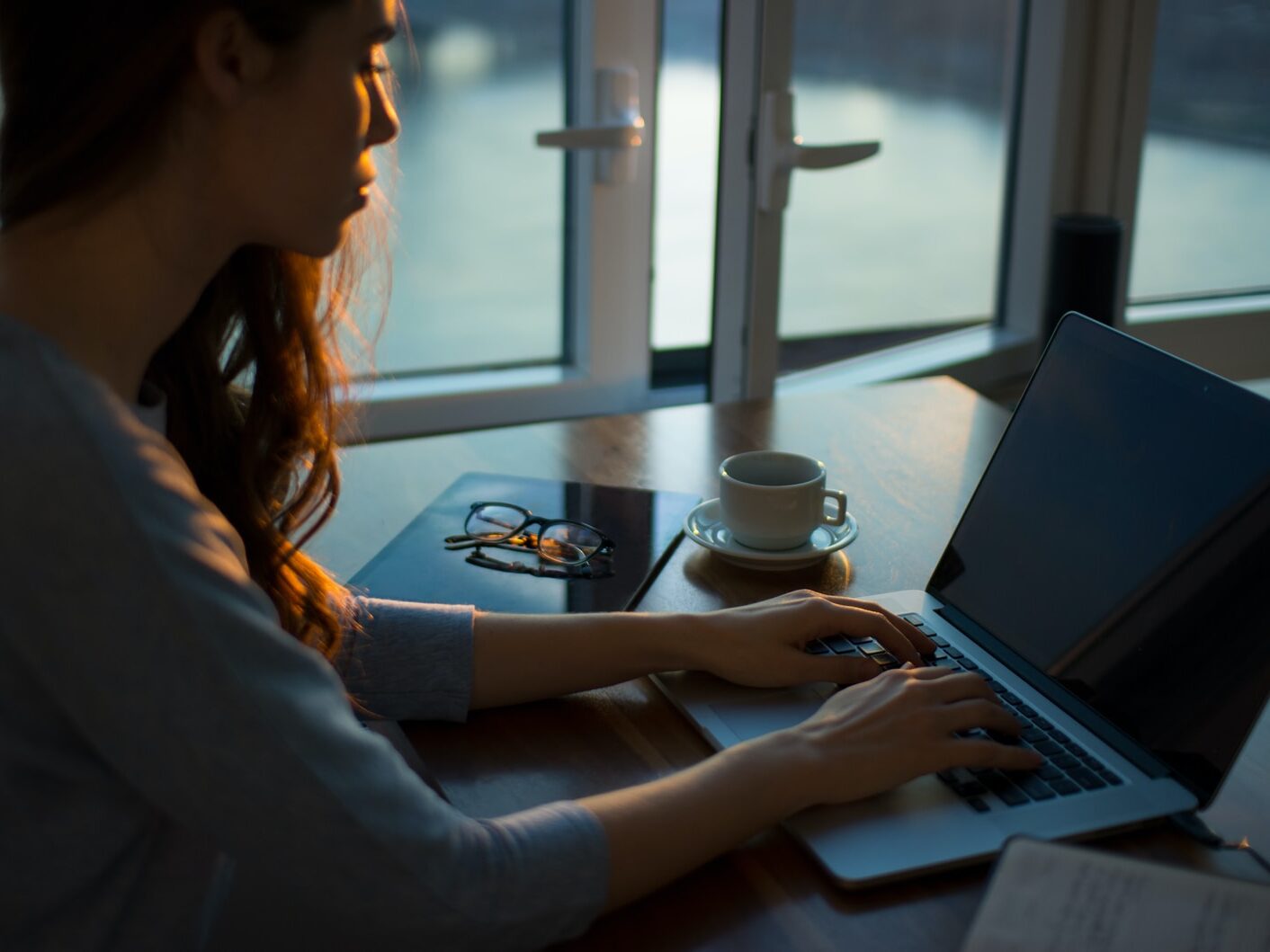 woman sitting beside table using laptop