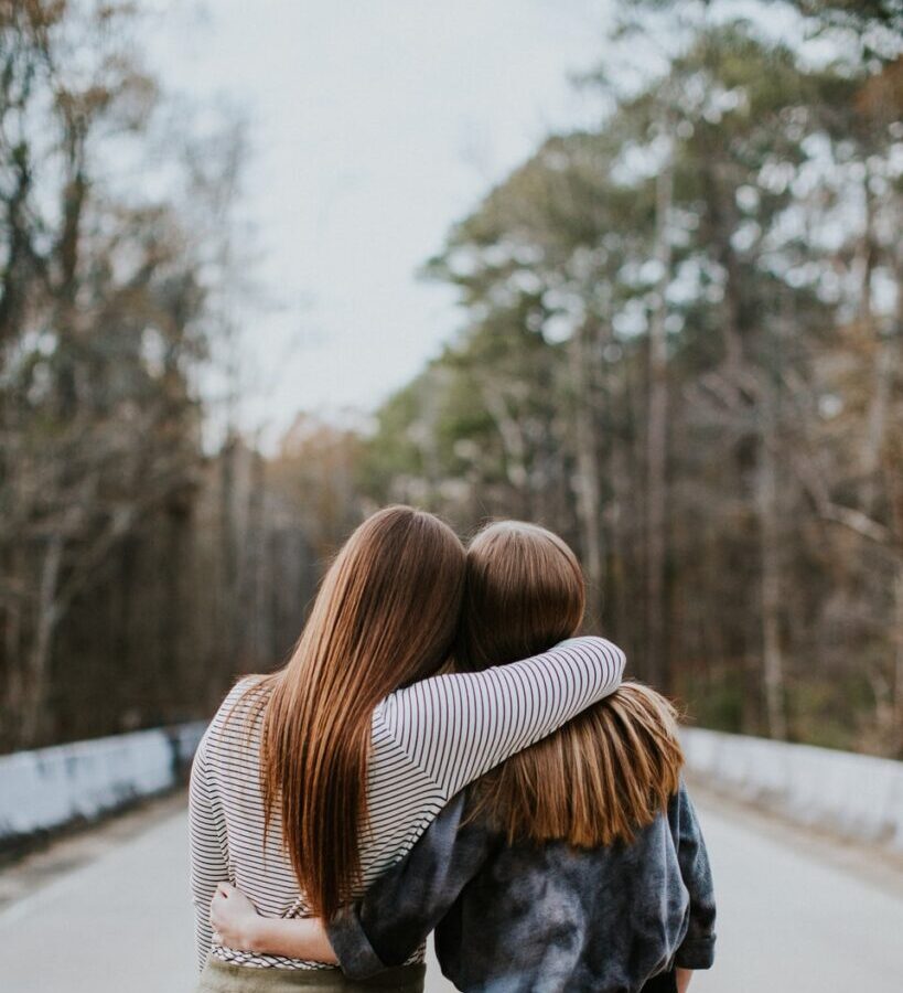 woman in black jacket standing on road during daytime