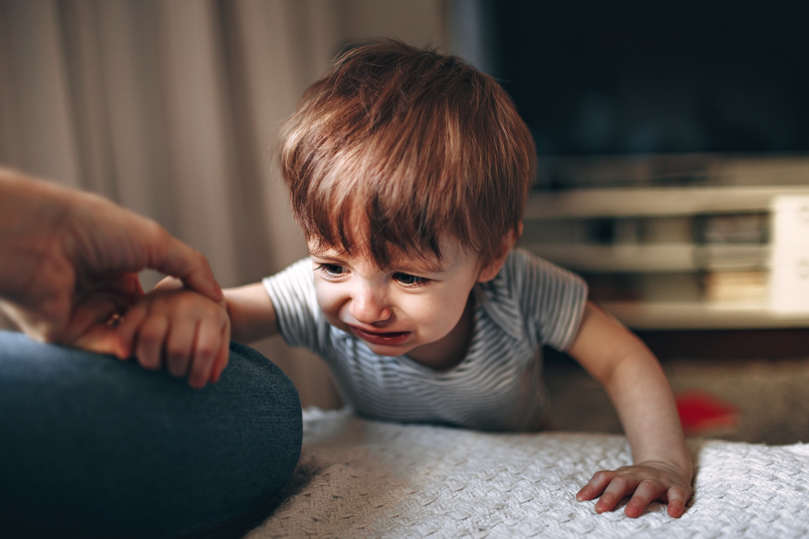boy in gray and white striped shirt sitting on floor