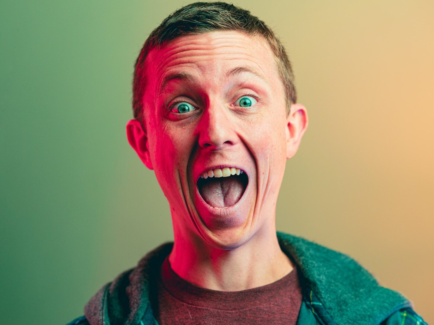 man in green crew neck shirt smiling