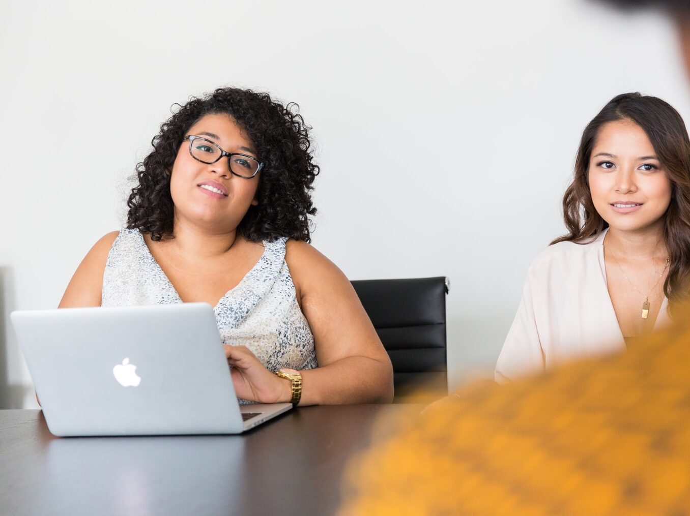 two women looking at person across the table