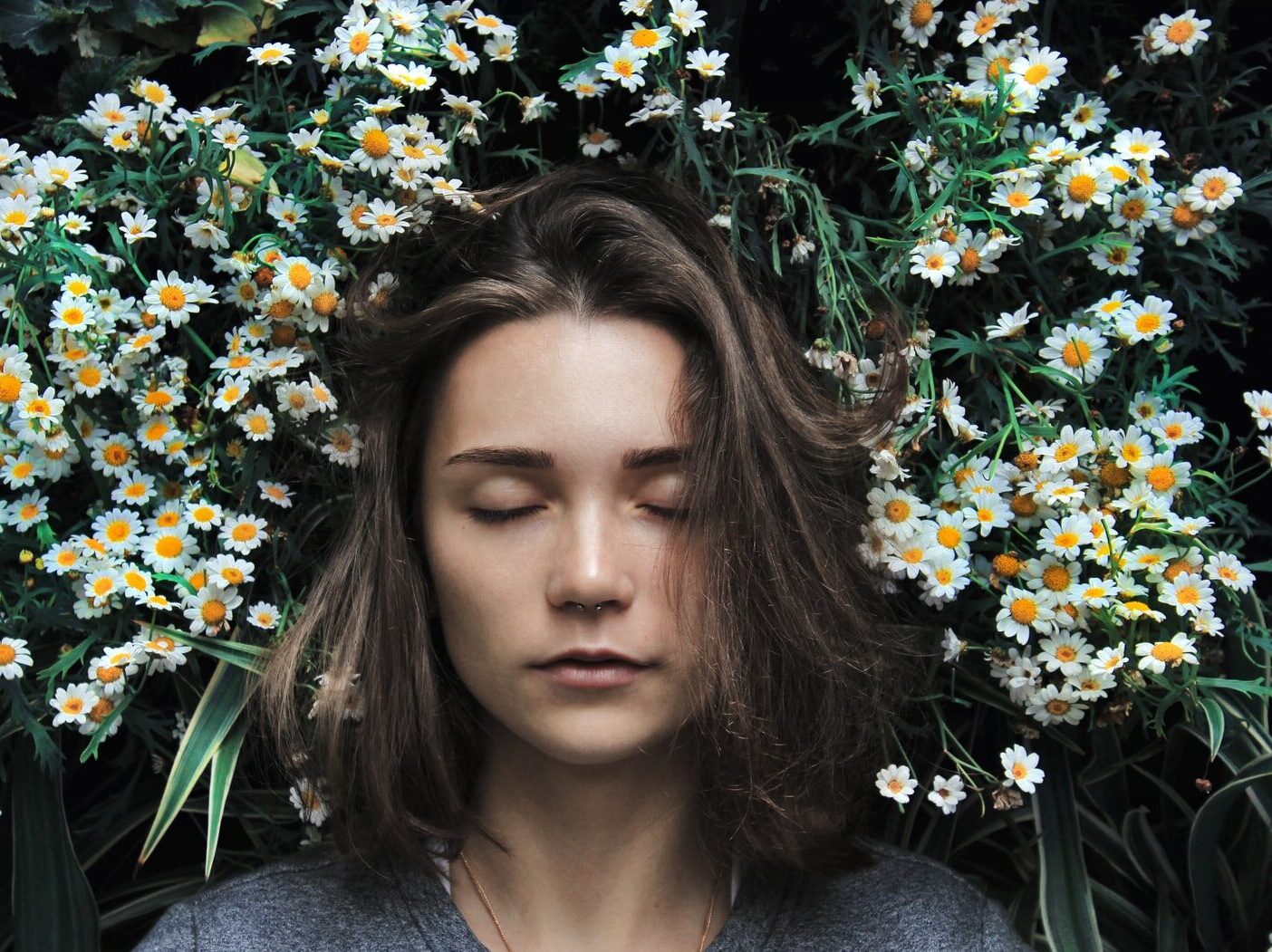 woman closing her eyes on white flower