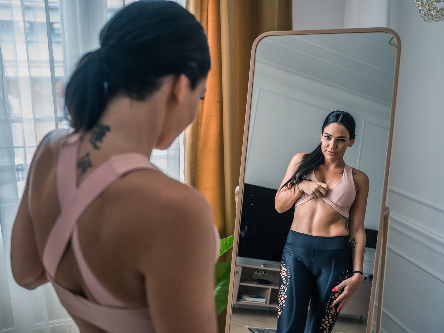 woman in black tube top and blue denim jeans standing beside man in black suit