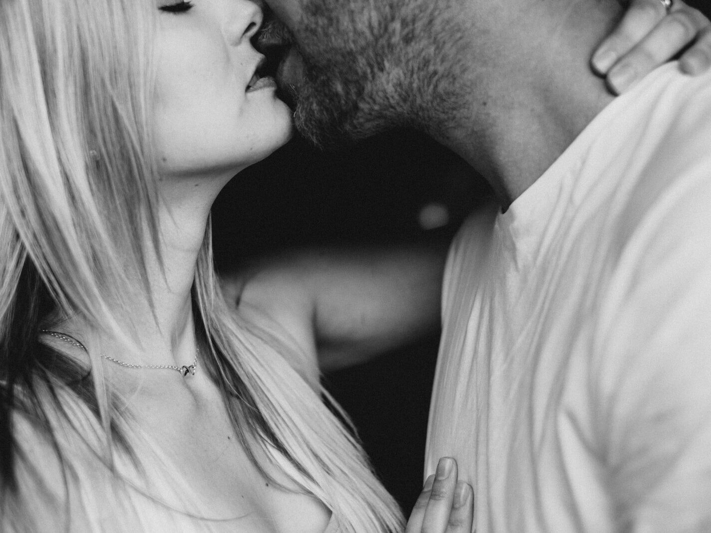 grayscale photography of man and woman kissing