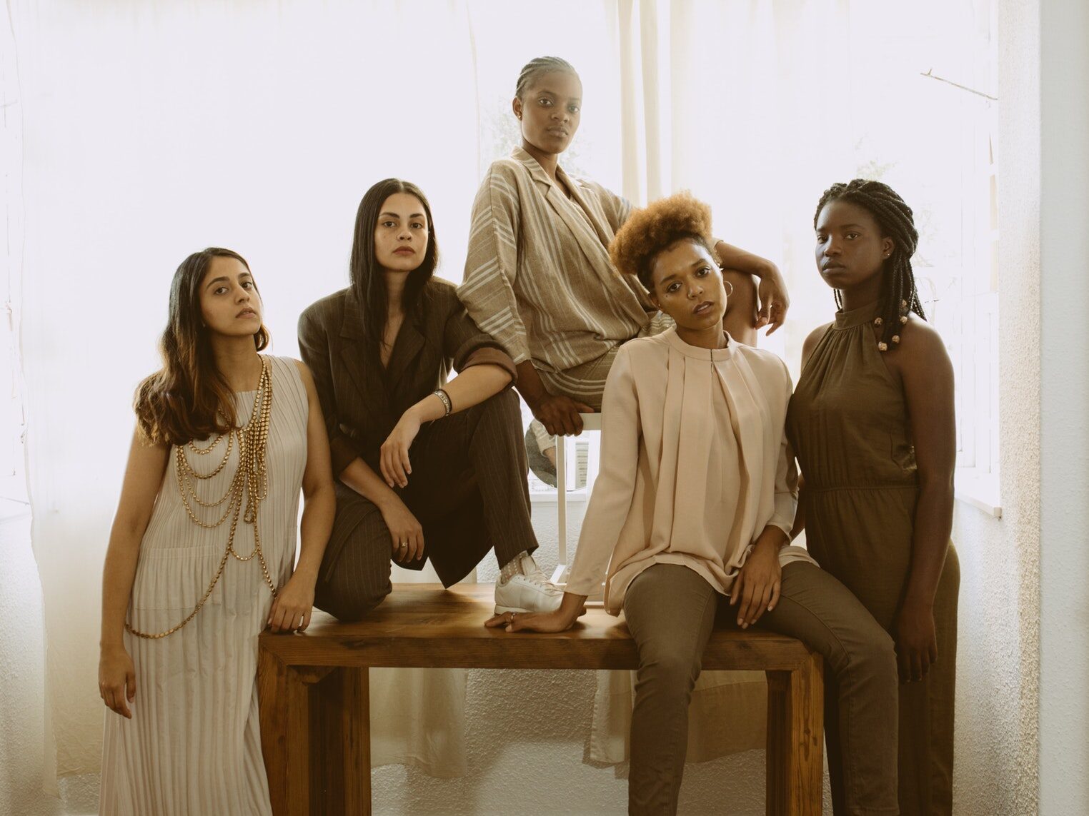 3 Women Sitting on Brown Wooden Bench