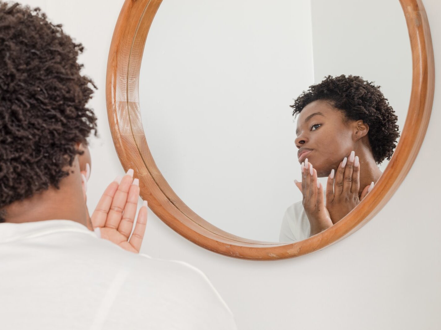 man wearing white shirt facing on wall mirror