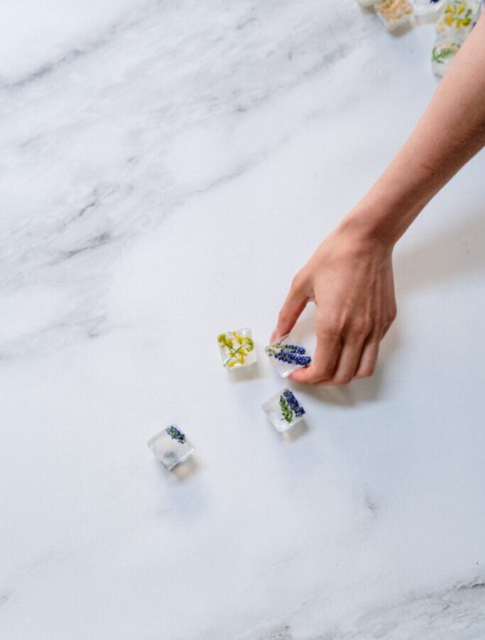 Person Holding Yellow and White Plastic Bottle