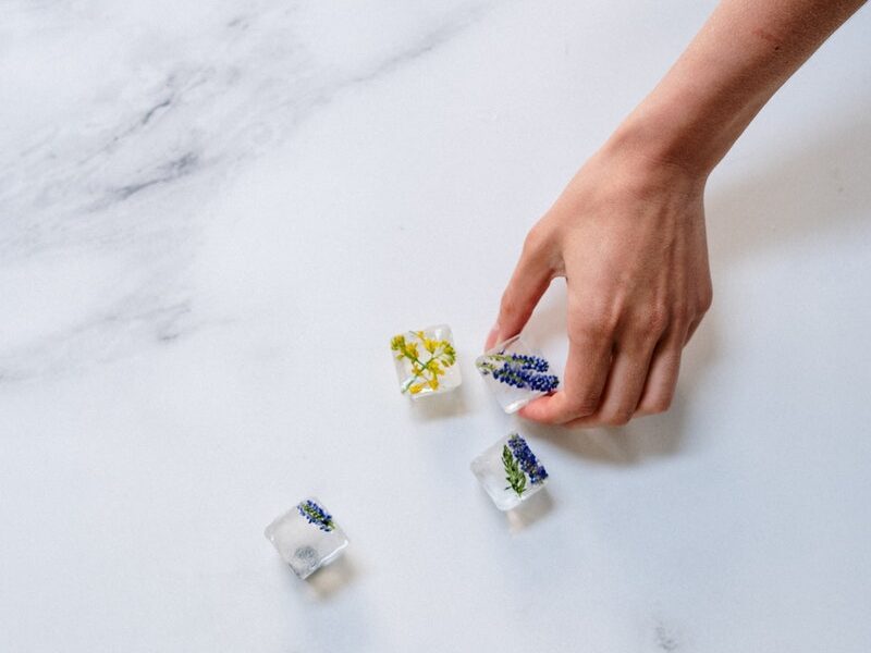 Person Holding Yellow and White Plastic Bottle