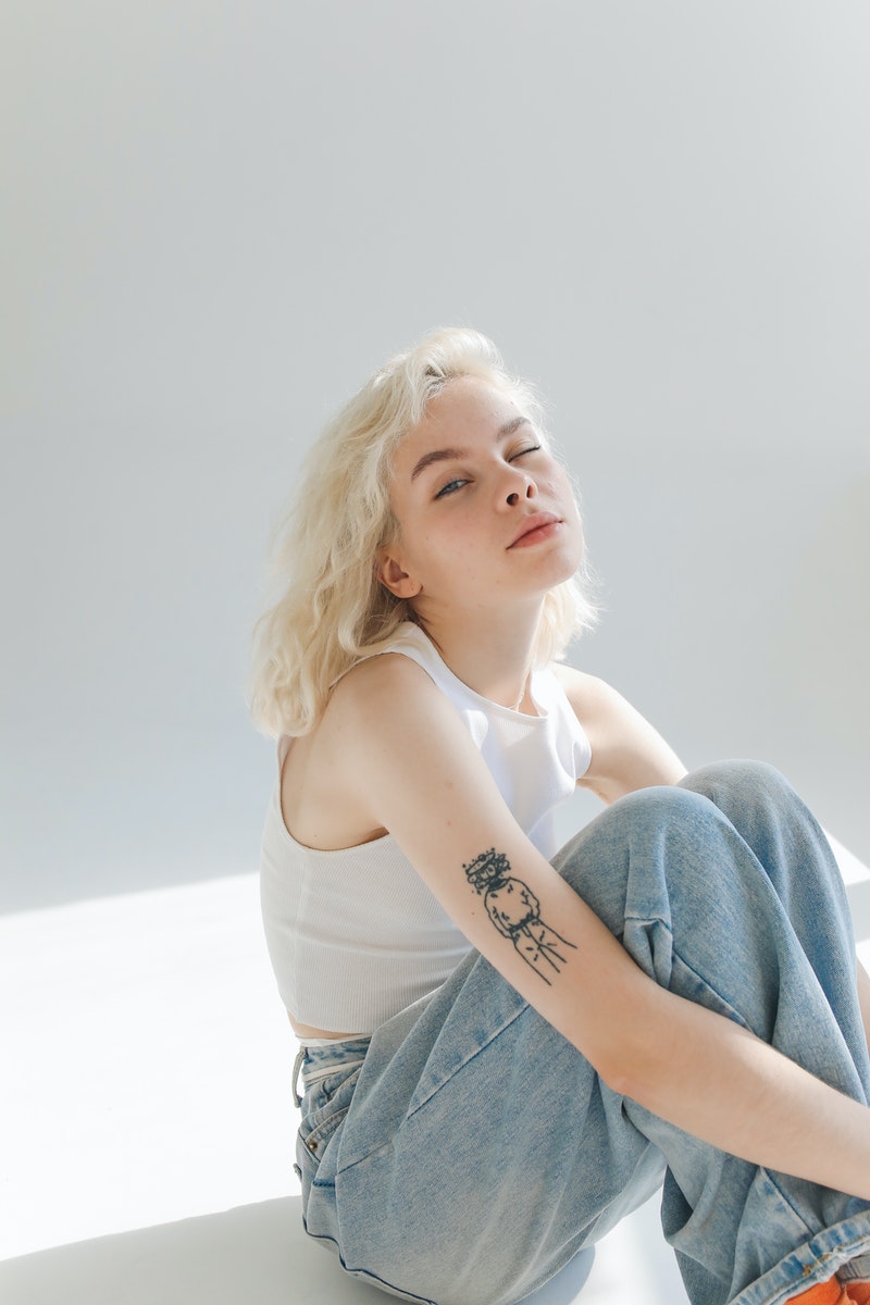 Woman in White Top and Blue Denim Jeans