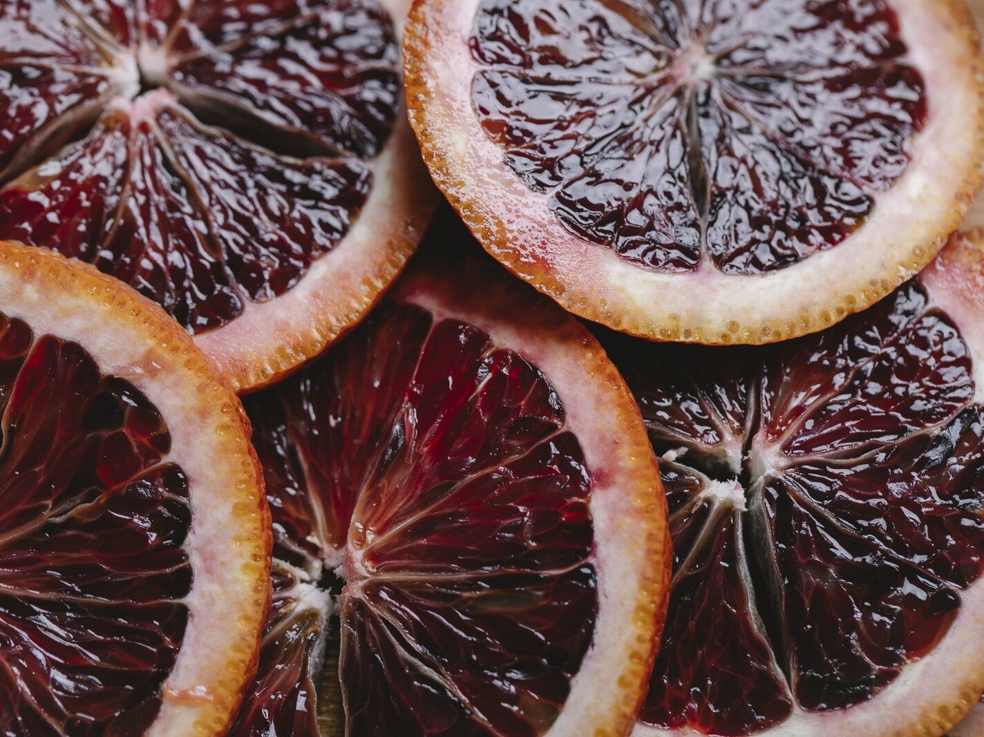 Top view closeup of sliced fresh ripe juicy tasty unpeeled fruit of red orange