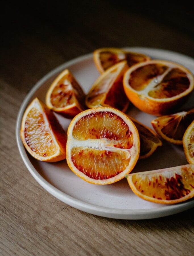 High angle of red oranges cut on halves and slices placed on plate
