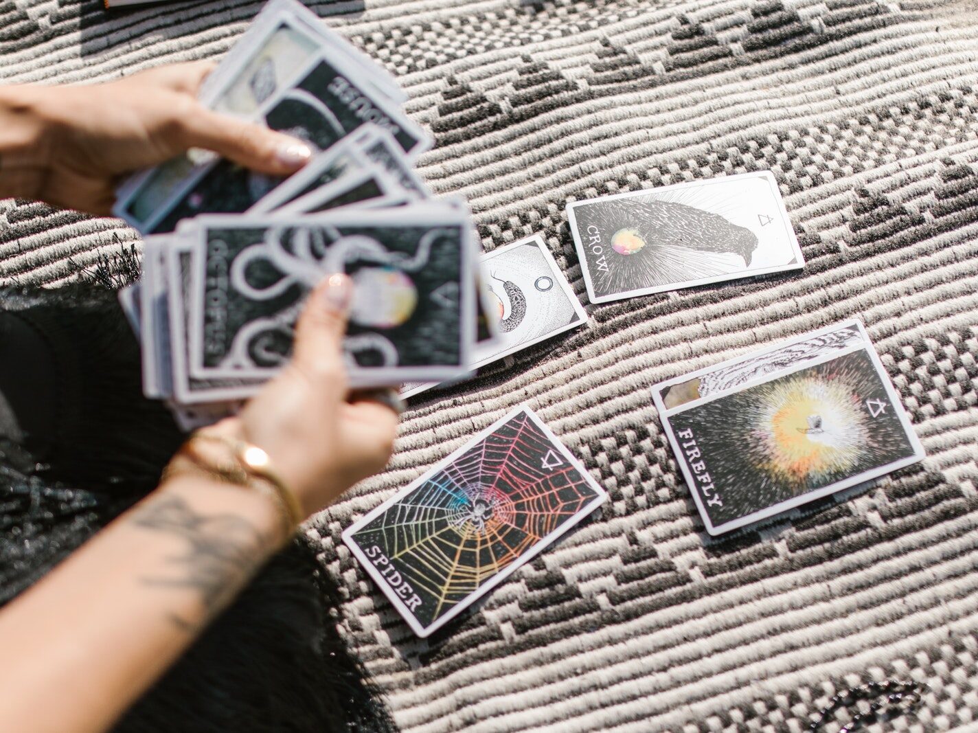 Person Holding Playing Cards on Black and White Textile