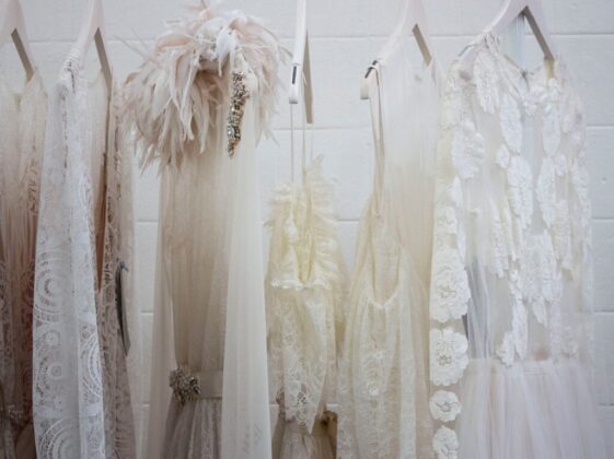 six women's white dresses hanging on hangers
